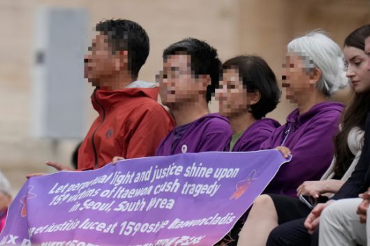 21일(현지시간) 바티칸 성 베드로 광장에서 레오 14세 교황 즉위 후 첫 주간 일반 알현이 진행된 가운데, 10·29 이태원 참사 유가족이 ‘희생자 159명에게 영원한 빛과 정의를 주소서’라는 문구가 적힌 보라색 현수막을 들고 있다. 2025.5.21 바티칸 AP 연합뉴스
