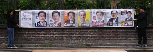 15일 서울 종로구 동숭동 예술가의집 담장에 서울시선거관리위원회 관계자들이 제21대 대통령 선거 벽보를 붙이고 있다. 2025.5.15. 안주영 전문기자