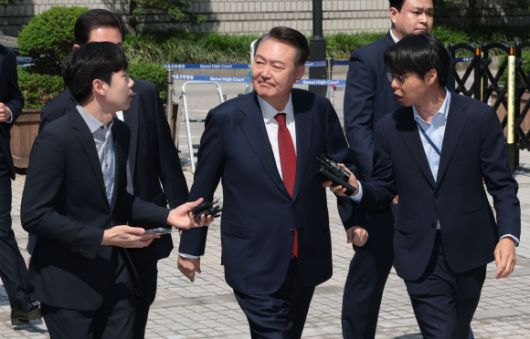 윤석열 전 대통령이 26일 서울 서초구 서울중앙지방법원에서 열린 내란 우두머리 혐의ㆍ직권남용 권리행사 방해 혐의 사건 5차 공판에 출석하며 지지자들을 바라보고 있다. 2025.5.26 사진공동취재단