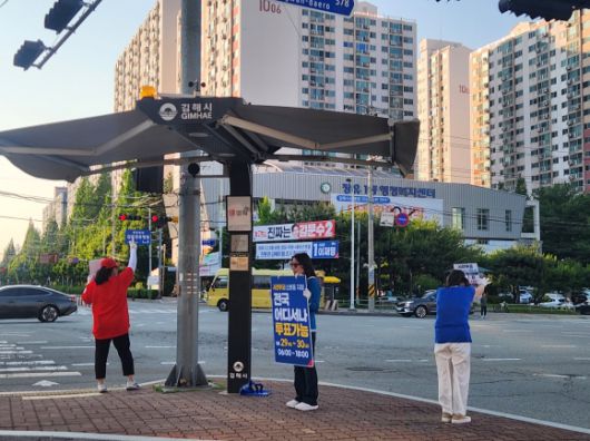 26일 경남 김해 장유IC에서 이재명 더불어민주당 대선 후보와 김문수 국민의힘 대선 후보의 선거 운동원들이 함께 서서 각각 선거 운동을 펼치고 있다. 김해 곽소영 기자