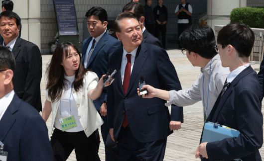 윤석열 전 대통령이 26일 서울 서초구 서울중앙지방법원에서 열린 내란 우두머리 혐의ㆍ직권남용 권리행사 방해 혐의 사건 5차 오전 공판을 마친 뒤 지지자들을 바라보며 차량으로 향하고 있다. 2025.5.26 사진공동취재단