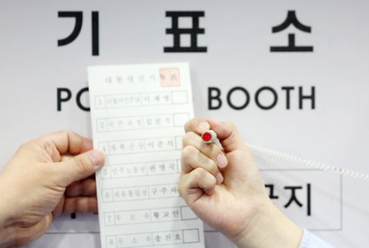 제21대 대통령선거 사전투표를 하루 앞둔 28일 서울 관악구 신사동 복합청사에 마련된 사전투표소에서 관계자가 투표지와 기표 도장을 들어 보이고 있다. 2025.5.28 [공동취재]