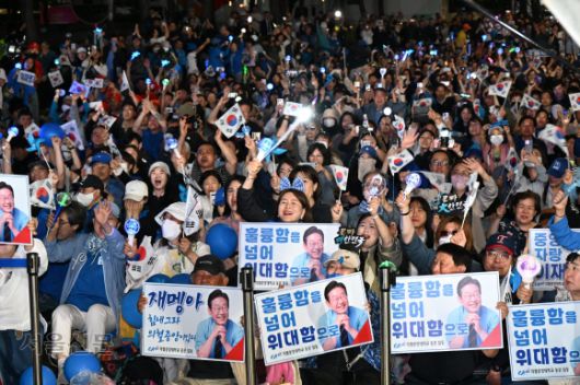 3일 밤 이재명 더불어민주당 대선 후보의 대통령 당선이 확정되자 서울 여의도 국회 앞에 모여 있던 지지자들이 태극기와 응원봉을 흔들며 환호하고 있다. 홍윤기 기자