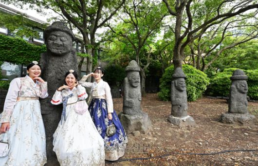 관광객이 제주목관아﻿ 돌하르방 앞에서 ﻿사진을 찍고 있다.