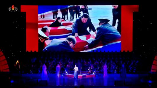 북한 조선중앙TV가 지난 29일 동평양대극장에서 방북 중인 올가 류비모바 러시아 문화부 장관이 참석한 가운데 열린 예술인 공연 중 무대 배경화면에 러시아 파병 북한군 전사자 유해 송환 장면을 30일 공개했다. 김정은 국무위원장이 ‘백두혈통’인 동생 김여정 노동당 부부장과 함께 전사자 시신을 인수하고 있다. 2025.6.30 조선중앙TV 화면 연합뉴스