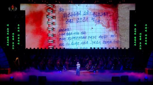 북한이 지난 29일 동평양대극장에서 방북 중인 올가 류비모바 러시아 문화부 장관이 참석한 가운데 열린 예술인 공연 중 무대 배경화면에 피로 얼룩진 수첩에 손글씨로 작성된 러시아 파병 북한군 편지가 상영됐다. 2025.6.30 조선중앙TV 화면 연합뉴스