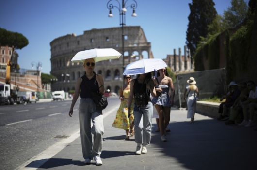 6월 30일 이탈리아 로마의 콜로세움을 지나가는 시민들이 양산을 쓰고 햇빛을 피하고 있다. AP 연합뉴스