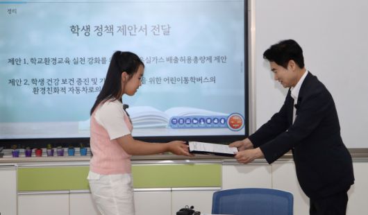 화순오성초 한 학생이 지구의 미래를 지키기 위한 약속과 정책 제안서를 김대중 전남교육감에게 전달하고 있다.