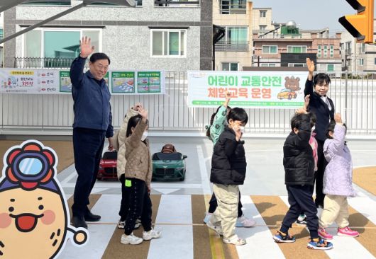 김종훈(왼쪽 첫 번째) 울산 동구청장이 지난 3월 12일 꽃바위체육센터 옥상에서 열린 어린이 교통안전 체험교육에 참가한 어린이들과 함께 손을 흔들고 있다.  울산 동구 제공