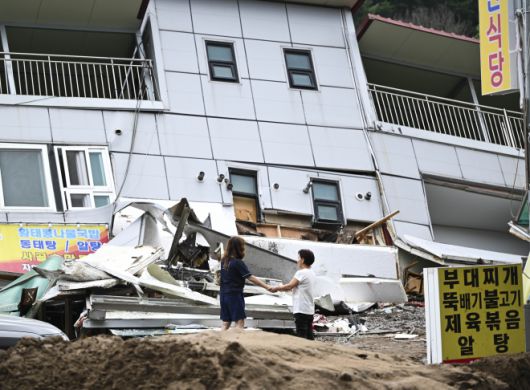 20일 폭우에 휩쓸려 붕괴된 경기 가평 한 건물 앞에서 주민들이 손을 맞잡고 있다. 이날 가평 일대에서는 밤사이 내린 폭우로 산사태와 범람 등이 발생해 2명이 사망하는 등 각종 인명 피해가 속출했다. 이날 가평의 누적 강수량은 오전 9시 30분 기준 197.5mm였다. 2025.7.20 이지훈 기자