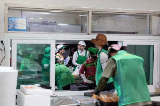 이재명 대통령 부인 김혜경(가운데) 여사가 24일 집중호우로 큰 피해를 본 경기 가평군 백둔리를 찾아 마을회관에서 자원봉사자들과 함께 대민 지원 활동에 나선 군장병 300여명에게 줄 점심 식사 준비를 하고 있다.  대통령실 제공