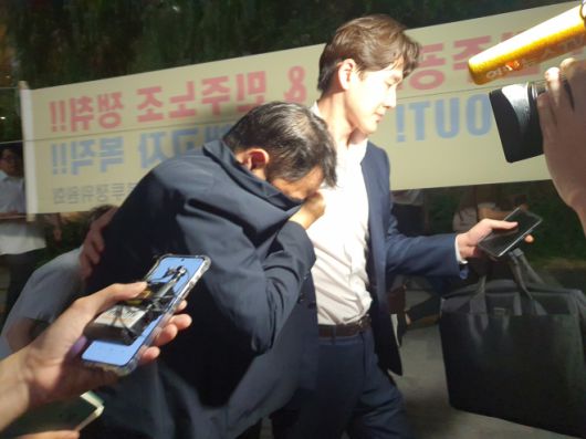 김건희 여사의 오빠 김진우 씨가 전날 김건희 특검팀(특별검사 민중기) 조사를 마치고 옷깃으로 얼굴을 가린 채 변호인 부축을 받으며 취재진을 피해 걸어가고 있다. 김 여사가 착용한 반클리프 아펠 목걸이는 김씨 장모 자택에서 발견됐다. 뉴스1