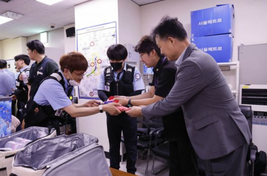 마해근 영업본부장과 문성호 시의원이 보안관에게 물품을 나눠주고 있다. 서울교통공사 제공