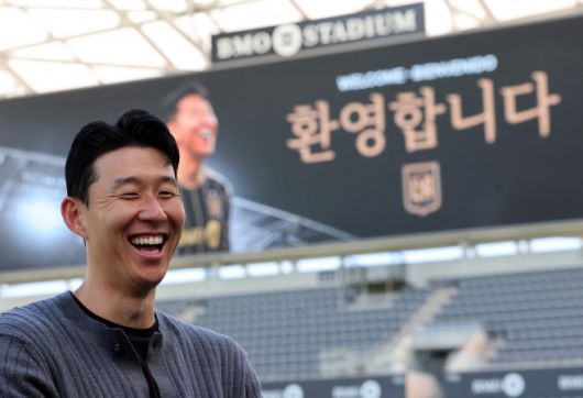 손흥민이 6일(현지시간) 미 프로축구(MLS) 로스앤젤레스(LA) FC의 홈구장인 BMO 스타디움에 6일(현지시간)에서 자신의 입단을 환영하는 대형 간판을 배경으로 밝게 웃고 있다. 2025.8.6 로스앤젤레스 AFP 연합뉴스