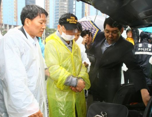 강씨가 아내를 살해한 부산 해운대구 모 호텔 인근 주차장에서 범행을 재연하고 있다. 연합뉴스