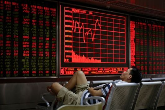 중국 베이징의 증권사 시황판 앞에서 한 남성이 잠을 자고 있다. 베이징 AP 뉴시스