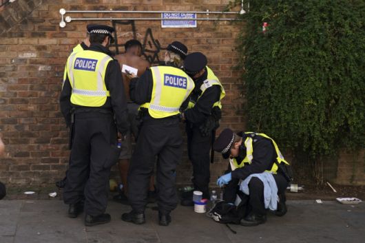 영국 런던 노팅힐 카니발 현장에서 두 참가자가 경찰에 체포되고 있다. 노팅힐 카니발은 유럽 최대 규모의 거리 축제이자 세계적으로 손꼽히는 카니발 중 하나다. AP 연합뉴스