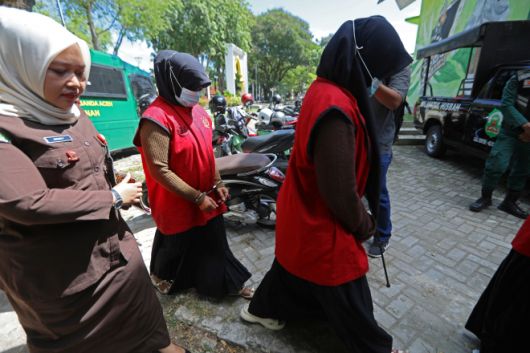 지난 26일(현지시간) 인도네시아 아체주 반다아체에서 진행된 태형 집행에서 태형을 선고받은 여성들이 현지 검찰의 호위를 받아 이동하고 있다. 아체주는 인도네시아에서 샤리아를 시행하는 유일한 지역으로, 동성애 관계 및 혼외 성관계 등을 불법으로 규정해 처벌한다. 2025.8.26 EPA 연합뉴스