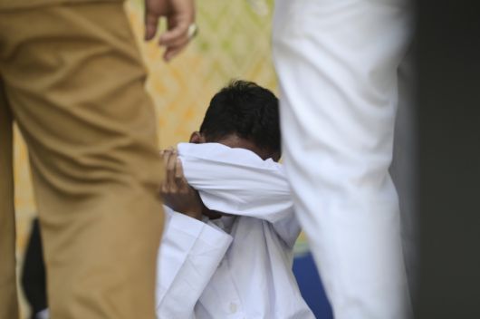공원 화장실에서 다른 남성과 키스해 샤리아(이슬람 율법)를 위반한 혐의로 유죄 판결을 받은 남성이 지난 26일(현지시간) 인도네시아 아체주 반다아체에서 진행된 태형 집행 후 바닥에 앉아 있다. 2025.8.26 AP 연합뉴스