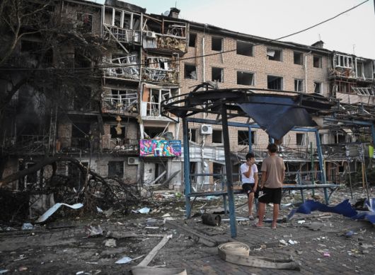 30일(현지시간) 우크라이나 자포리자에서 러시아의 드론·미사일 공습으로 피해를 본 아파트 건물 앞에 주민들이 서 있다. 로이터 연합뉴스