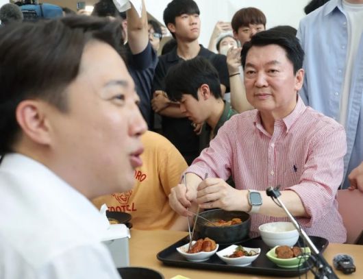 국민의힘 안철수 의원이 21일 경기 성남시 가천대학교 글로벌캠퍼스에서 열린 ‘학식 먹자 이준석’ 행사에 참석한 가운데 학생들과 대화를 나누는 개혁신당 이준석 대선 후보를 바라보고 있다. 연합뉴스