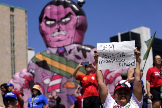 Brazil Protest - 2025년 9월 21일 일요일 브라질리아에서 2023년 쿠데타 시도 혐의로 유죄 판결을 받은 자이르 보우소나루 전 대통령과 그 동맹자들을 사면할 수 있는 사면 법안에 반대하는 시위자들이 ‘사면 반대’가 적힌 종이를 들고 서 있다. AP 연합뉴스