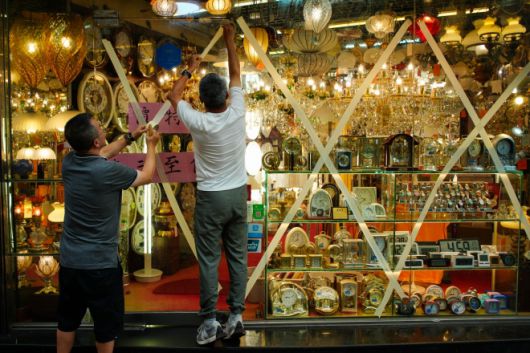 2025년 9월 22일, 중국 남부 홍콩에서 직원들이 상점 유리창에 접착용 테이프를 붙이고 있다. 홍콩 특별행정구 보안국 산하 긴급 모니터링·지원센터는 태풍 ‘라가사’에 대비해 월요일 오전 가동됐다. 신화 뉴시스