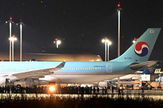 2025년 10월 18일 캄보디아 캔달주 테초국제공항에서 한국 경찰 관계자들이 송환용 전세기 인근에 서 있다. 캄보디아 당국은 온라인 사기 단속 과정에서 구금된 한국인 60여 명을 이날 새벽 한국으로 송환했다. AFP 연합뉴스