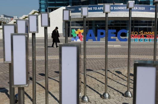 2025 아시아태평양경제협력체(APEC) CEO 정상회의가 열리는 경주 행사장 앞을 한 남성이 지나가고 있다. 2025년 10월 29일. 로이터 연합뉴스