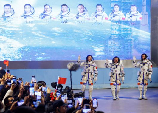 31일 중국 간쑤성 주취안 위성발사센터에서 열린 환송식에서 션저우 21호 우주비행 임무에 참여하는 우주비행사 장홍장, 장루, 우페이가 손을 흔들고 있다. 주취안 로이터 연합뉴스