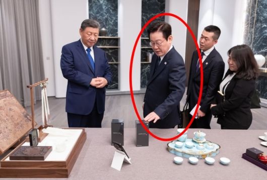 이재명 대통령과 시진핑(왼쪽) 중국 국가주석이 1일 경북 소노캄 호텔에서 국빈만찬 전 서로를 위해 준비한 선물을 보고 있다. 시 주석이 선물한 샤오미 휴대전화를 이 대통령이 만져보고 있다. 연합뉴스