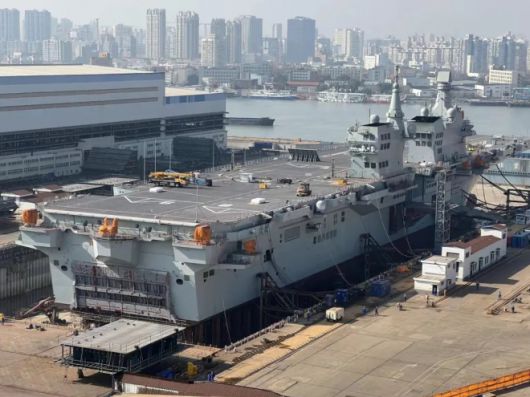중국 상하이 후둥-중화 조선소 드라이독에 정박한 중국 해군의 076형 강습함 ‘쓰촨’. 비행갑판에는 사출기 뒤쪽의 폭풍 방지판(블라스트 디플렉터)이 들어 올려진 모습이 확인되며, 사출·회수 체계와 연계된 장치로 추정되는 구조물도 관측된다. 중국 인터넷 캡처