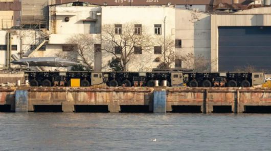 중국 상하이 후둥-중화 조선소 부두에서 트럭형 전자기 사출기 모듈이 열차처럼 연결된 모습. 앞서 육상에서 포착된 이동식 전자기 사출 체계와 구조적으로 동일한 형태로, 여러 대의 차량이 하나의 연속된 사출 궤도를 이루고 있다. 인근에는 임시 수상 전투함으로 개조된 화물선이 정박해 있었다. 중국 인터넷 캡처