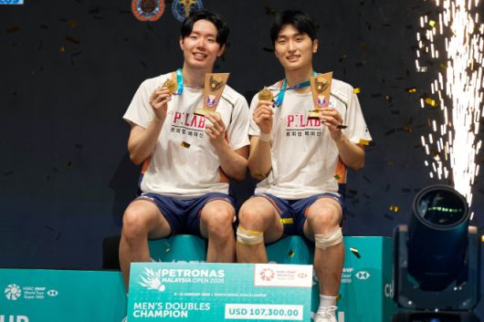 남자 복식 결승에서 우승한 뒤 트로피와 메달을 들어보이는 서승재(왼쪽)와 김원호. 쿠알라룸푸르 AP 연합뉴스