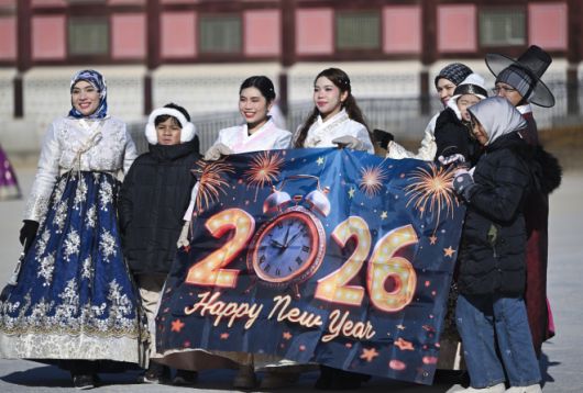 병오년(丙午年) 새해 첫날인 1일 서울 종로구 광화문에서 외국인 관광객들이 새해 기념 현수막을 들고 경복궁 흥례문을 배경으로 추억을 남기고 있다. 이지훈 기자