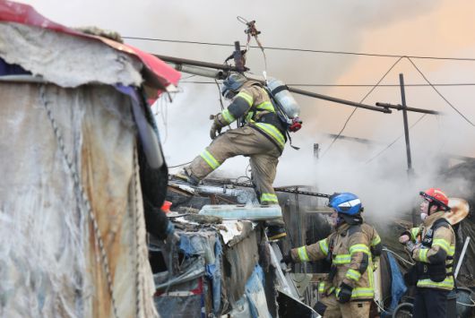 지난 16일 서울 강남구 개포동 구룡마을에서 소방관들이 잔불을 진압하고 있다. 연합뉴스