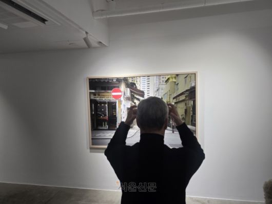 전시된 사진을 찍을 당시 상황을 재연하는 모습.