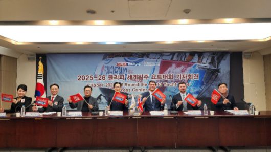 22일 클리퍼 세계일주 요트대회 기자회견에 참석한 관계자들이 대회 깃발을 들어 보이고 있다. 경남도 제공