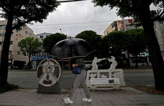 5·18 사적지 제21호 ‘5·18 최초 발포지’. 1980년 5월19일 계엄군이 비무장 시민을 향해 최초로 총을 쏜 광주 동구 중앙로 282 앞을 우산을 받쳐 쓴 한 시민이 걸어가고 있다. 계엄군 장갑차가 시위 군중에게 포위되자 시민을 향해 발포해 당시 조선대 부속고등학교 3학년에 재학 중이던 김영찬이 손과 허벅지에 세 발의 총상을 입었다.