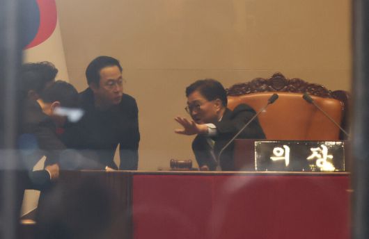 비상계엄 해제 요구 결의안이 통과된 2024년 12월4일 새벽 국회 본회의장 의장석에서 우원식 국회의장이 대화를 나누고 있다. 연합뉴스