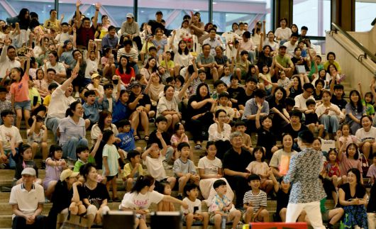 7월4일 저녁 서울 종로구 서울역사박물관에서 열린 ‘일루션 매직쇼’에서 문준호 마술사(뒷모습)가 200여 명의 학부모와 아이들과 함께 마술쇼를 진행하고 있다.