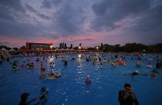 7월5일 야간 개장한 서울 영등포구 한강공원 여의도 수영장에서 많은 시민이 물놀이하고 있다. 서쪽 하늘이 붉게 물들었다.