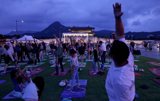 7월4일 저녁 서울 종로구 세종로 광화문광장에서 외국인을 위한 영어 요가가 열리고 있다. 참석자들이 강사의 안내대로 자세를 취하고 있다.