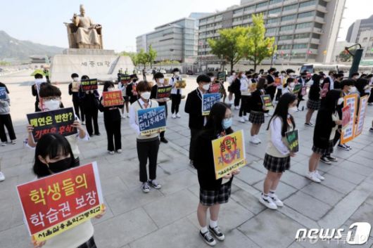 (서울=뉴스1) 이광호 기자 = 서울실용음악고등학교 학생들이 6일 오전 서울 광화문광장에서 학교 정상화 촉구 및 학생 법적조치 협박에 대한 이사회 규탄 기자회견을 하고 있다. 학생들은 기자회견에서 학교장의 비도덕적이고 독단적인 행태와 학교 설립자는 학교의 연습장을 개인 목적으로 무단 사용하며 학생들의 학습권을 침해하고 있다고 주장했다. 또한 주차장에서 배식을 하는 등 급식실도 보장받지 못하고 있다고 설명했다. 서울실용음악고등학교는 지난해 8월 개교 이후 첫 서울시교육청 감사에서 설립자이자 전 교장이 가족을 동원해 학생들이 지급한 수업료 20여억원을 부당 사용하고 회계 장부를 조작한 정황이 드러났다. 설립자 일가는 감사 결과에 불복해 교육청을 상대로 행정소송을 진행 중이다.2020.5.6/뉴스1