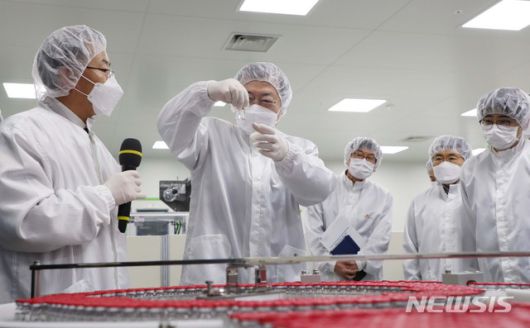 [안동=뉴시스]추상철 기자 =문재인 대통령이 20일 오전 경북 안동시 SK바이오사이언스 공장 코로나19 백신 완제 제조실에서 분류중인 백신을 들어보이고 있다. SK바이오사이언스 공장에서는 국민들의 코로나19 예방 접종을 위해 공급될 아스트라제네카 백신을 위탁생산하고 있다. 2021.01.20. scchoo@newsis.com