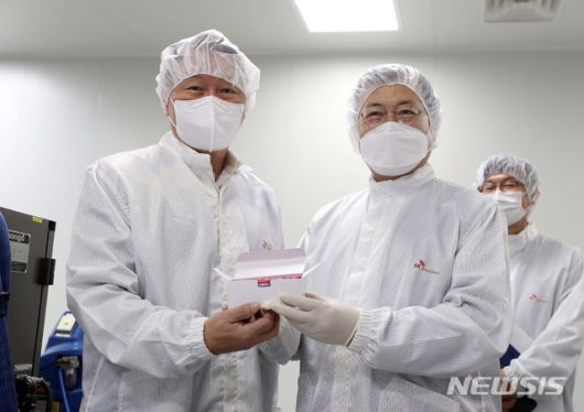 [안동=뉴시스]추상철 기자 =문재인(오른쪽) 대통령과 최태원 SK회장이 20일 오전 경북 안동시 SK바이오사이언스 공장 코로나19 백신 완제 제조실에서 분류중인 백신을 들어보이고 있다. SK바이오사이언스 공장에서는 국민들의 코로나19 예방 접종을 위해 공급될 아스트라제네카 백신을 위탁생산하고 있다. 2021.01.20. scchoo@newsis.com