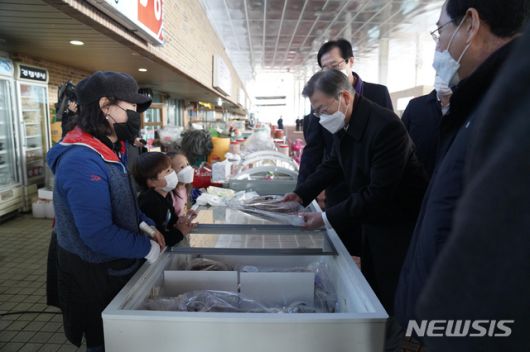 [신안=뉴시스]박영태 기자 = 문재인 대통령이 5일 오후 설 연휴 임시개통 예정인 전남 신안군 임자2대교에서 열린 세계 최대 해상풍력단지 48조원 투자협약식 체결 후 신안젓갈타운을 방문해 민어를 구매하고 있다. 2021.02.05. since1999@newsis.com