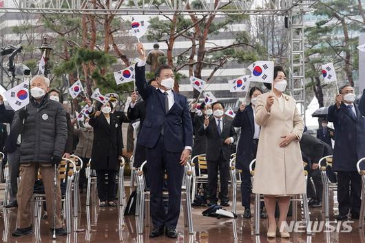 [서울=뉴시스추상철 기자 = 문재인 대통령와 김정숙 여사가 1일 오전 서울 종로구 탑골공원에서 열린 제102주년 31절 기념식에 참석해 태극기를 흔들고 있다. 2021.03.01. scchoo@newsis.com