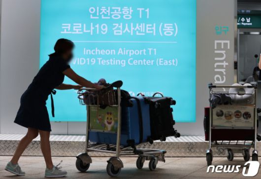 (인천공항=뉴스1) 이재명 기자 = 25일 오전 인천국제공항 제1여객터미널에 마련된 신종 코로나바이러스 감염증(코로나19) 검사센터로 출국을 앞둔 시민들이 검체검사를 받기 위해 들어서고 있다.  1터미널 검사센터는 오전 7시부터 오후 6시까지 운영하며 홈페이지 예약 후 이용할 수 있다. 2021.8.25/뉴스1