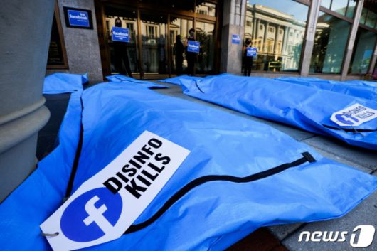 (워싱턴 로이터=뉴스1) 이정후 기자 = 28일(현지시간) 미국 워싱턴 페이스북 지사 앞에서 코로나19 허위 정보를 규제하지 않는 페이스북에 항의하기 위해 시위대가 시체 가방을 전시하고 있다.  (C) 로이터=뉴스1